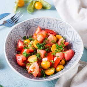 Appetizing salad with physalis, tomatoes and dill in a bowl. Vegetarian diet.
